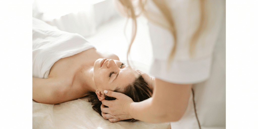A close-up view of a relaxed patient lying down while receiving a specialized head and neck treatment from a practitioner. This illustrates how Registered Massage Therapy and chiropractic care at Port Perry Wellness Centre help relieve physical tension and reduce stress.