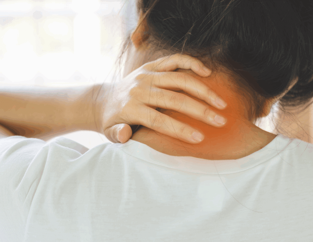 A person seen from behind with their hand clutching the back of their neck, indicating discomfort. A soft red glow is overlaid on the neck area to highlight the location of pain or tension.
